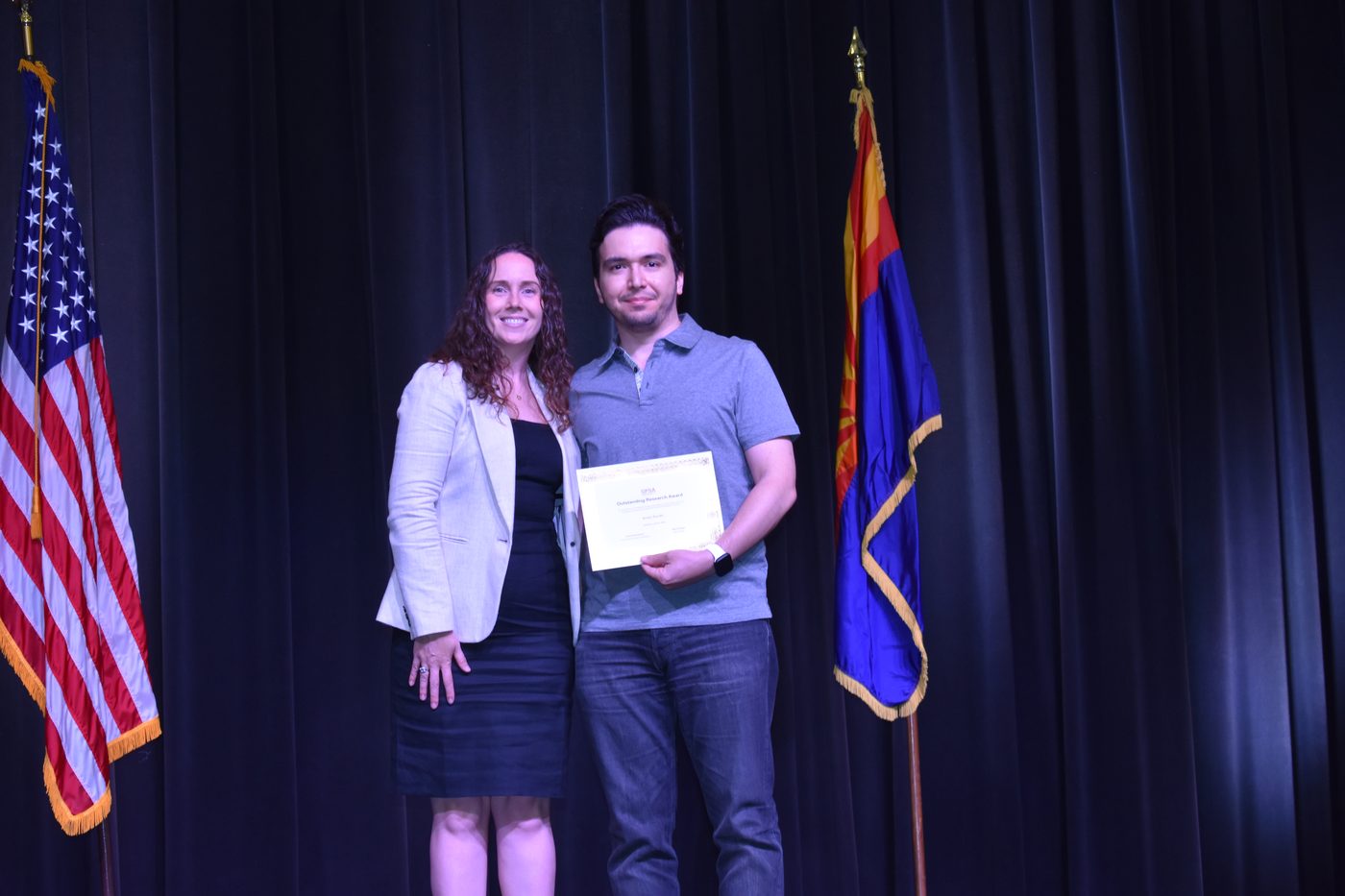 Arash Sarabi receiving the GPSA Outstanding Research Award certificate on stage at Arizona State University