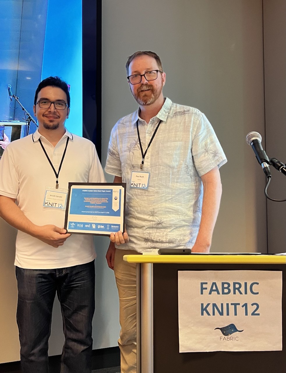 Arash Sarabi receiving the FABRIC Golden Stitch Best Paper Award plaque from Paul Ruth at KNIT12 in Honolulu, Hawaii